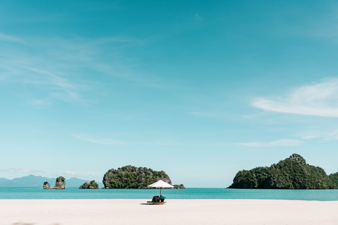 A sandy beach with a boat in the water