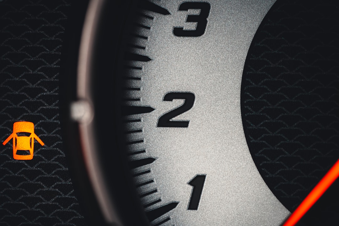 a close up of a speedometer with an orange needle