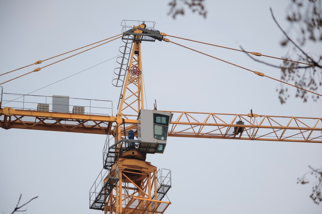a yellow crane with a man on top of it