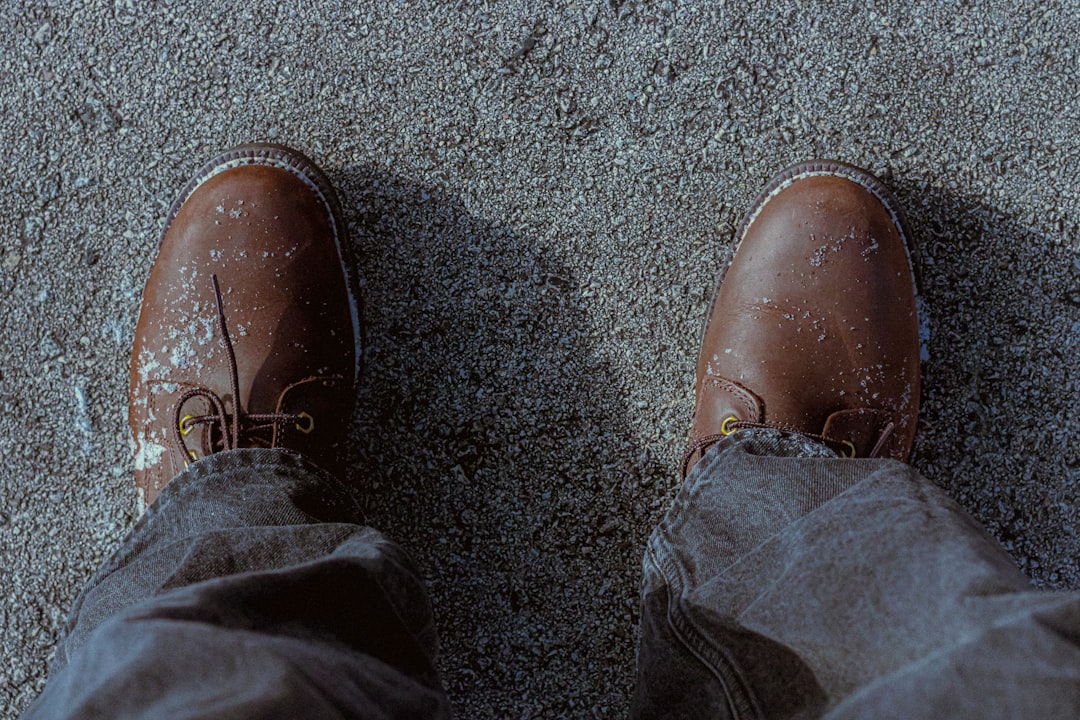Brown leather boots on a person's feet.
